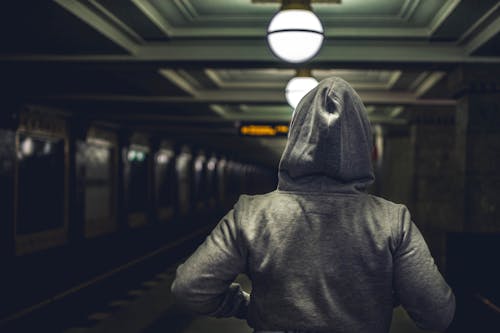 Persona Vestida Con Chaqueta Con Capucha Gris En La Estación De Tren