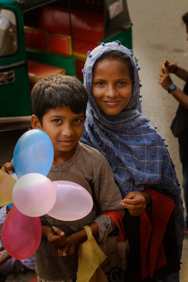 Boy Holding Balloons Beside A Girl