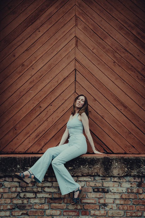Woman Sitting in front of Wooden Wall