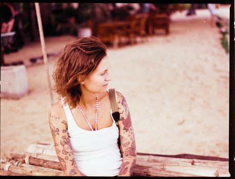 Tattooed Woman Sitting on Wooden Raft