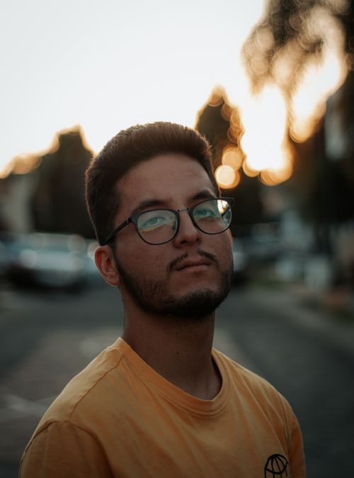Free Close-up portrait of a young man wearing glasses at sunset. Stock Photo