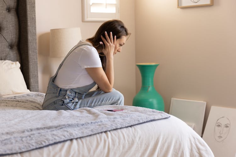 Worried Woman Sitting On Bed