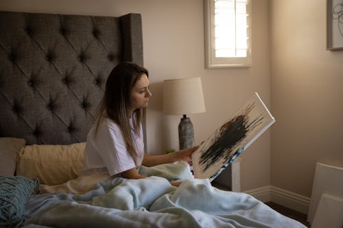 Photo of a Woman Holding a Painting