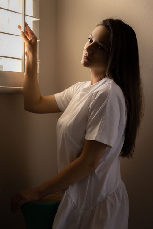 A Woman Posing Near a Window