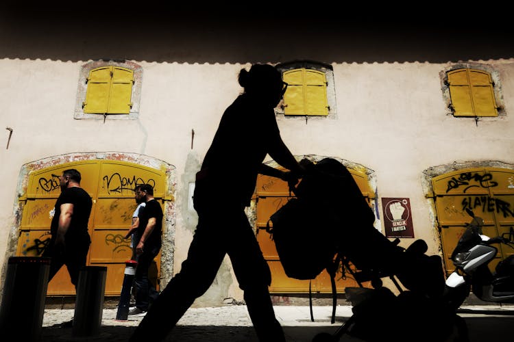 Silhouette Of A Person Pushing A Trolley 