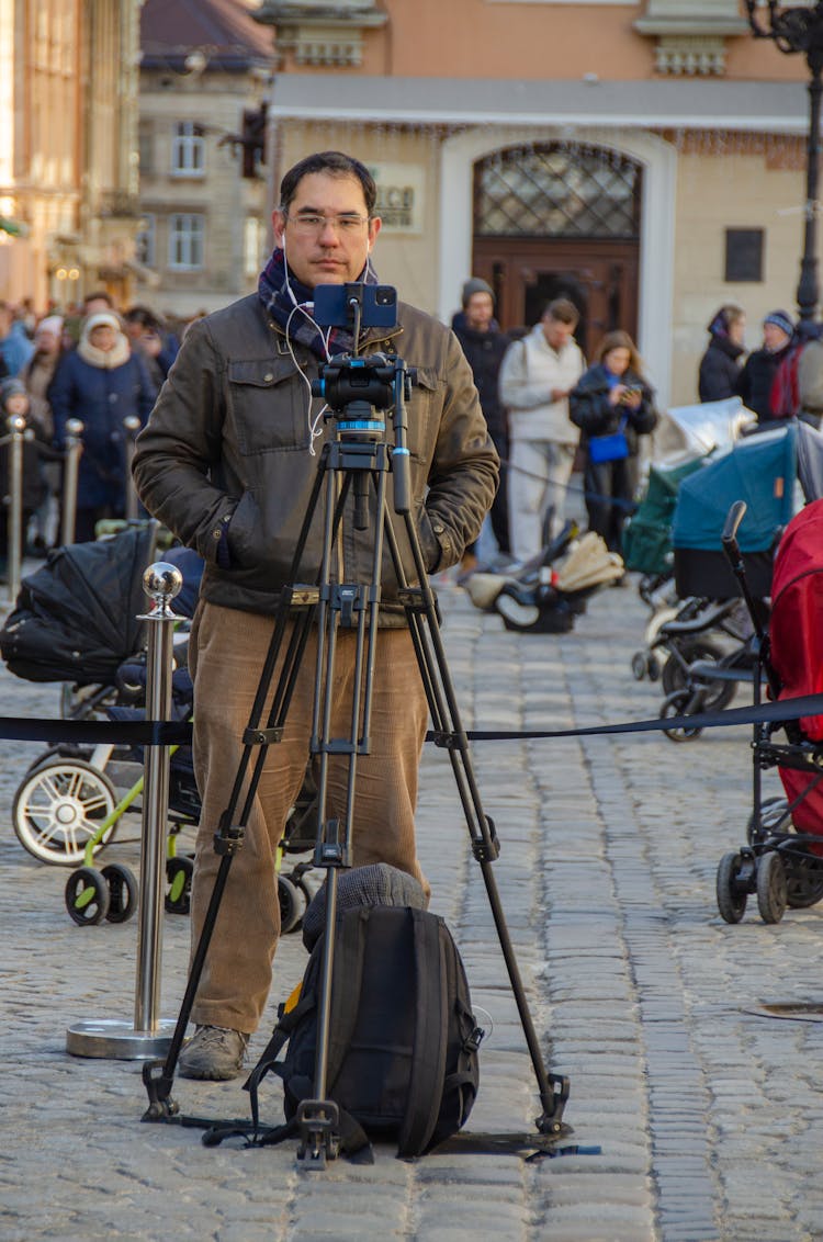 Man Filming With Cellphone On Tripod On Street