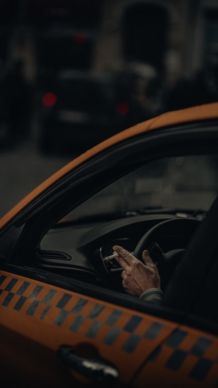 A Person Driving While Smoking A Cigarette