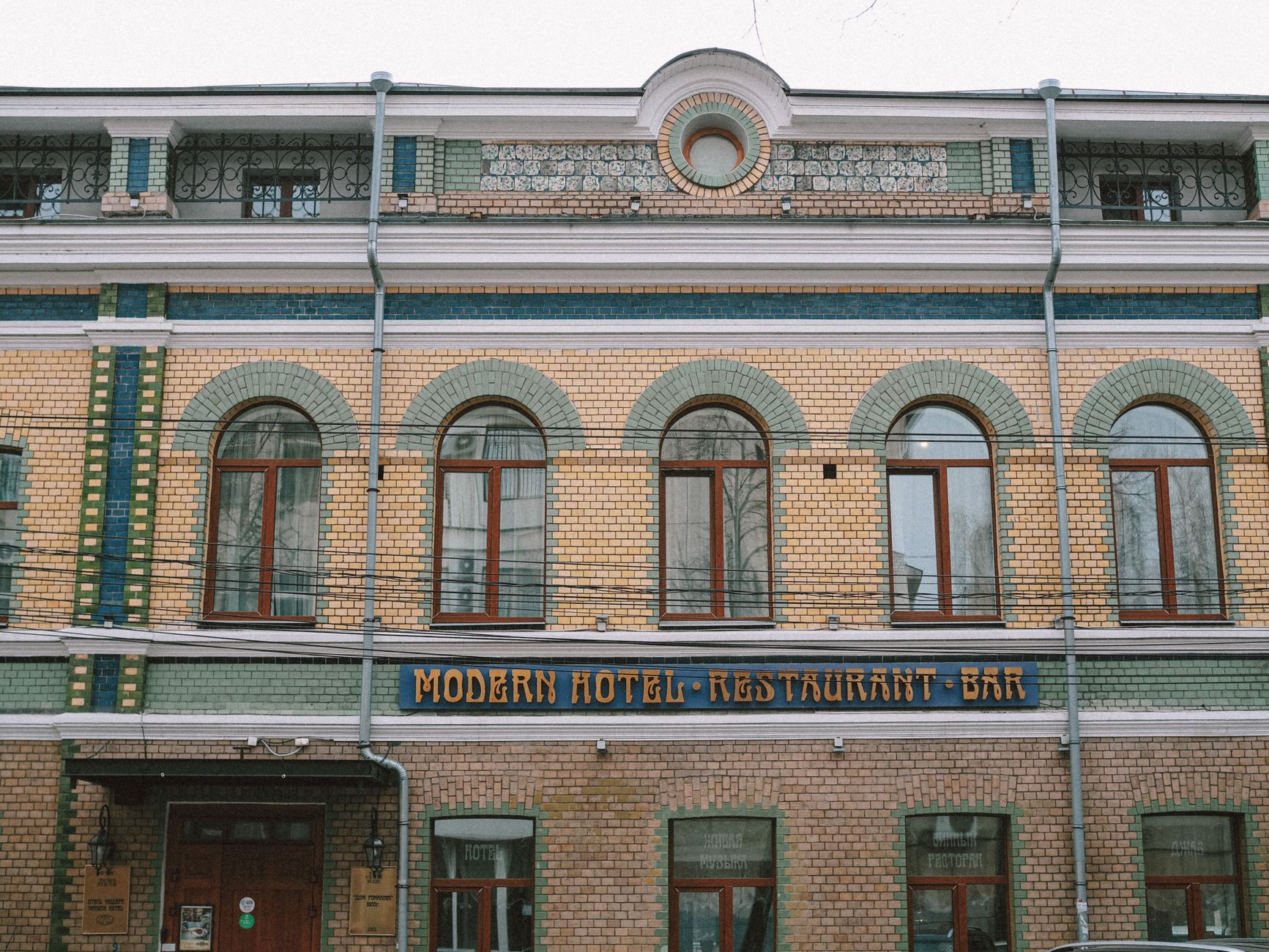 Historic building facade with arched windows and 'Modern Hotel Restaurant Bar' sign.
