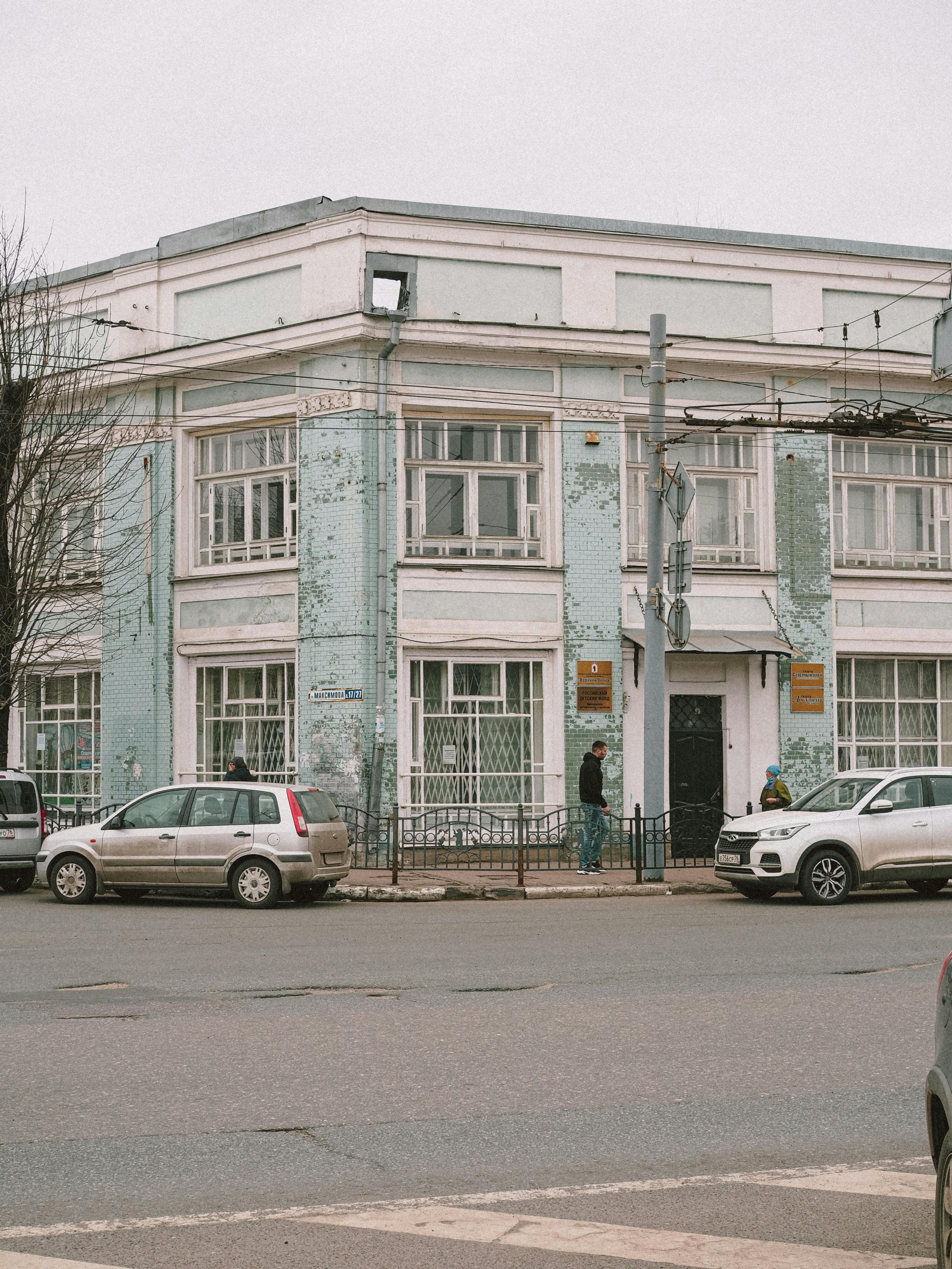 Free Vintage building with cars parked on a street corner in an urban setting. Stock Photo