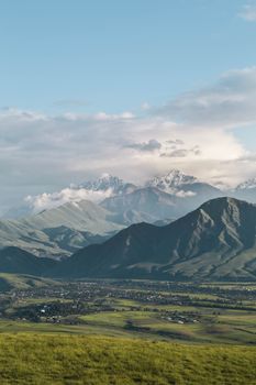 吉尔吉斯斯坦山脉的风景中，一个村庄作为前景，捕捉了自然美景