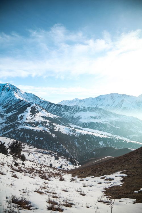 Free Breathtaking view of snow-covered mountains under clear blue skies, capturing the essence of winter. Stock Photo
