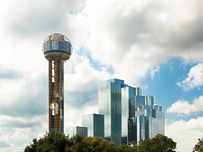 Reunion Tower and downtown Dallas skyscrapers against a cloudy sky