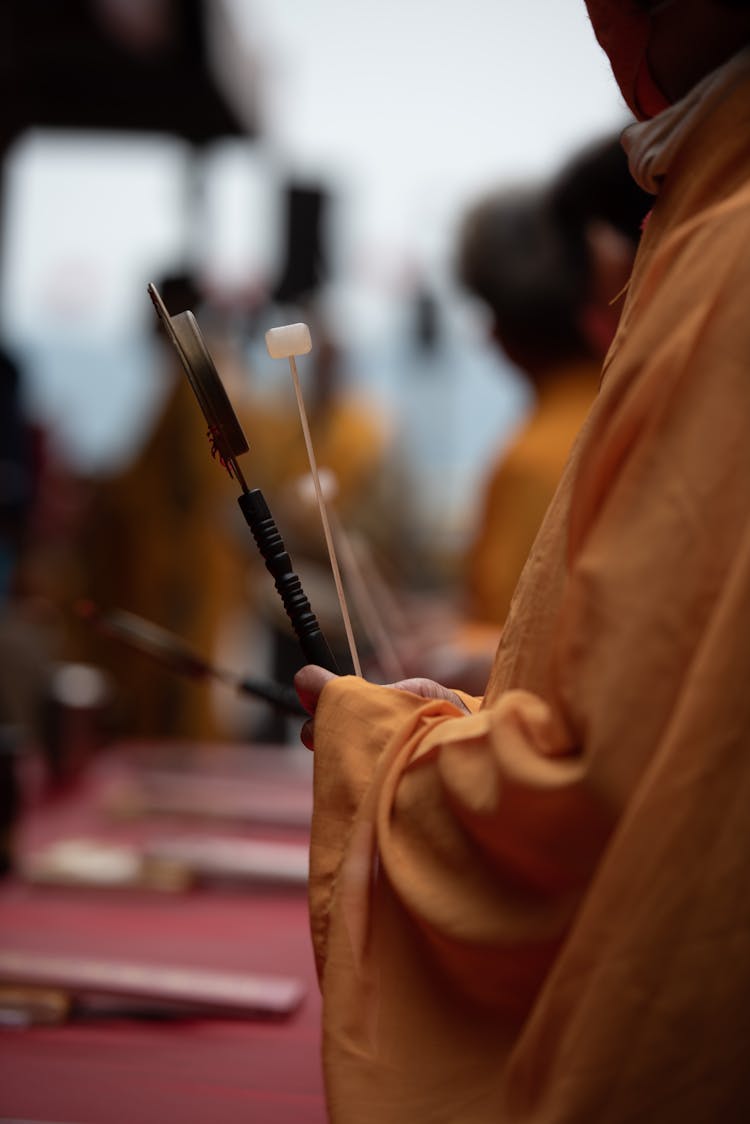 Hands In Robes Holding Sticks