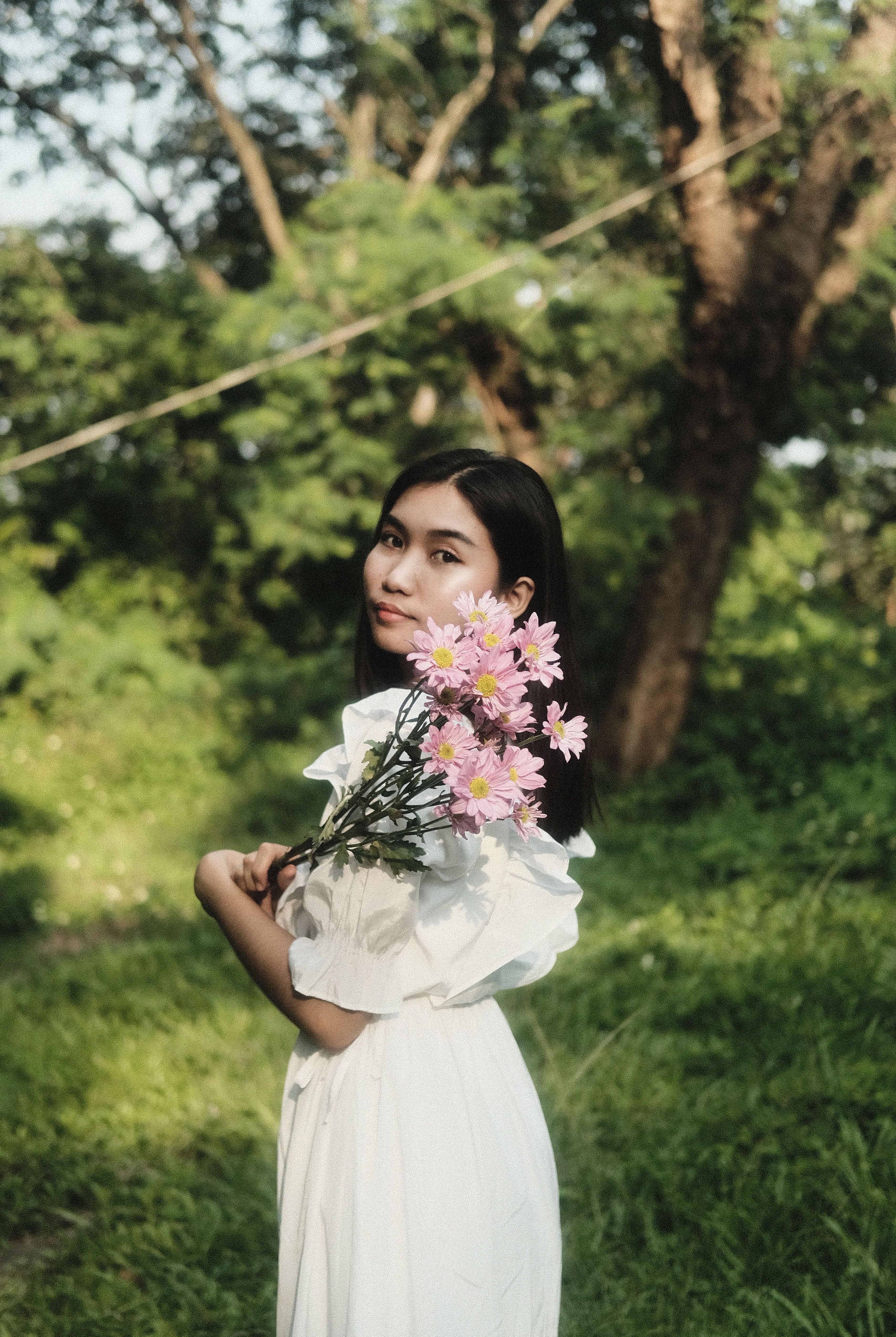 Woman Holding Pink Flowers on a Plant · Free Stock Photo
