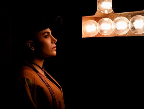 Dramatic profile portrait of a woman bathed in warm, artistic light.