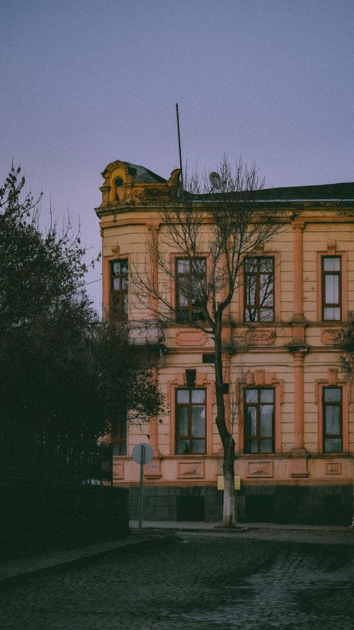 Free Charming old building with intricate architecture on a cobblestone street at twilight. Stock Photo