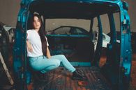 A Woman in White Shirt Inside a Junk Vehicle