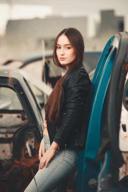 Download A Woman In A Black Jacket Standing In Front Of A Car Wallpaper