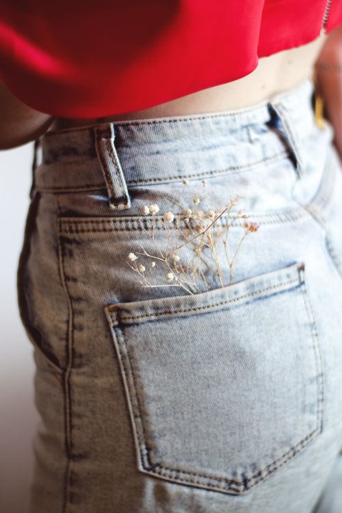 Free Close-up of denim jeans pocket with baby's breath flowers, captured from behind. Stock Photo
