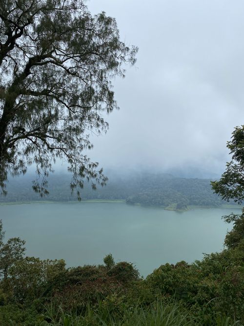 Free Serene misty view of a lake surrounded by lush trees in Bali, Indonesia. Stock Photo