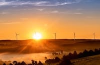 Wind Turbines on Green Grass Field during Sunset