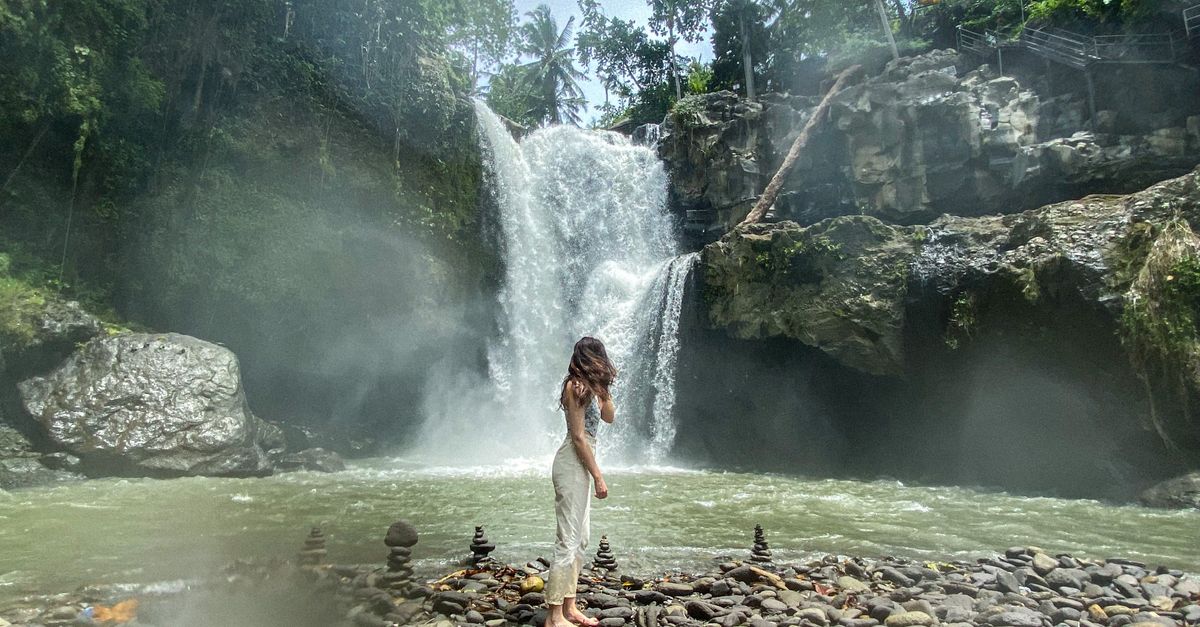 Woman In Waterfall Woman Standing in front of Majestic Waterfall · Free Stock Photo