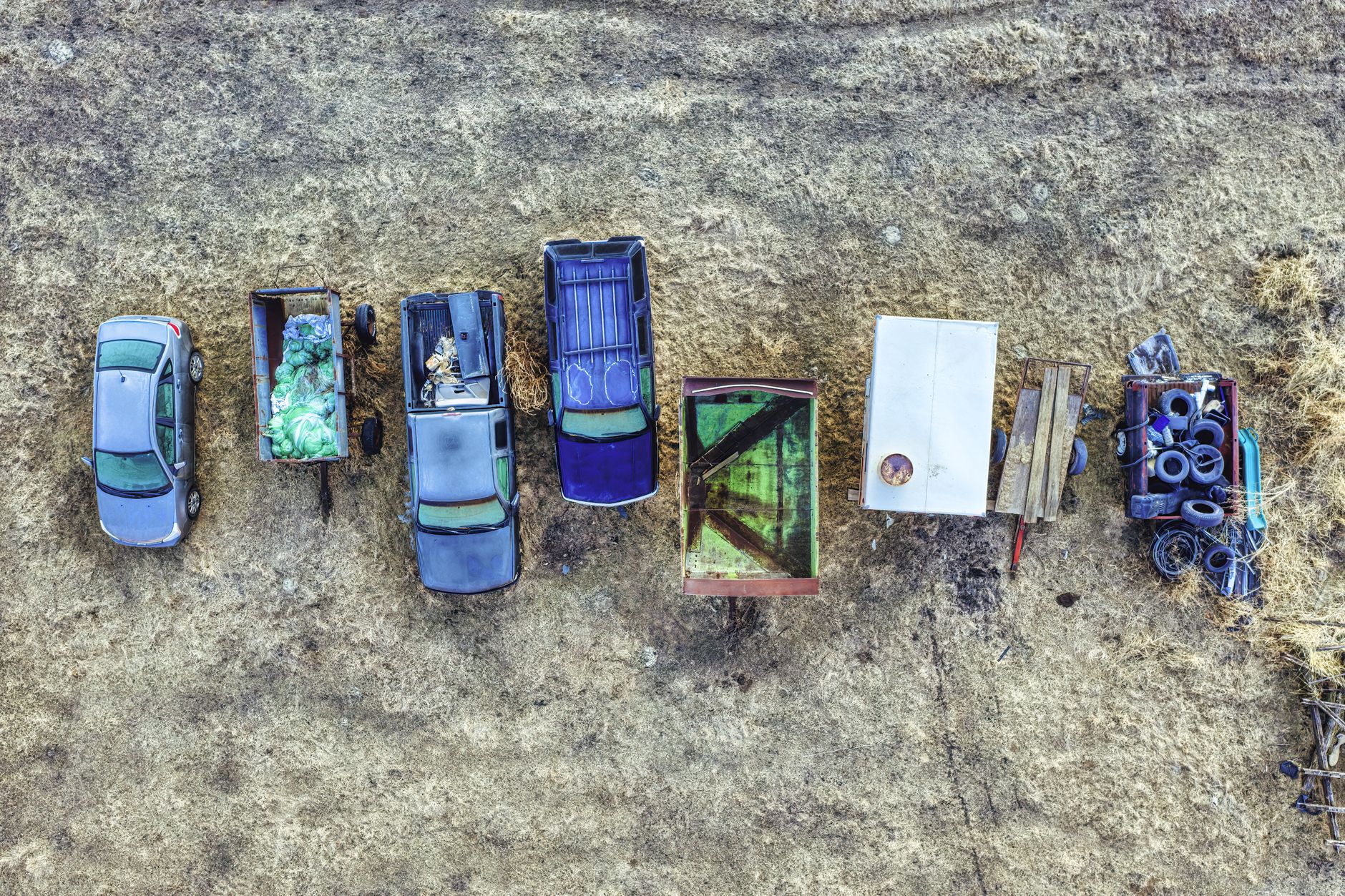 Bird's-eye view of multiple parked vehicles and trailers on a rural area in Minnesota, USA.