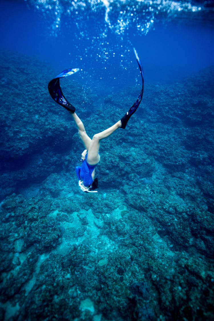 A Woman Diving Towards The Sea Floor