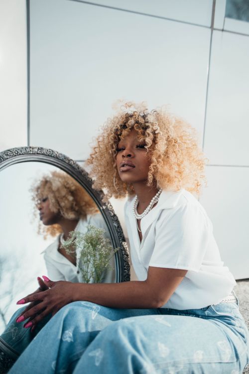 Free Stylish woman poses outdoors with mirror reflection, showcasing fashion and elegance. Stock Photo