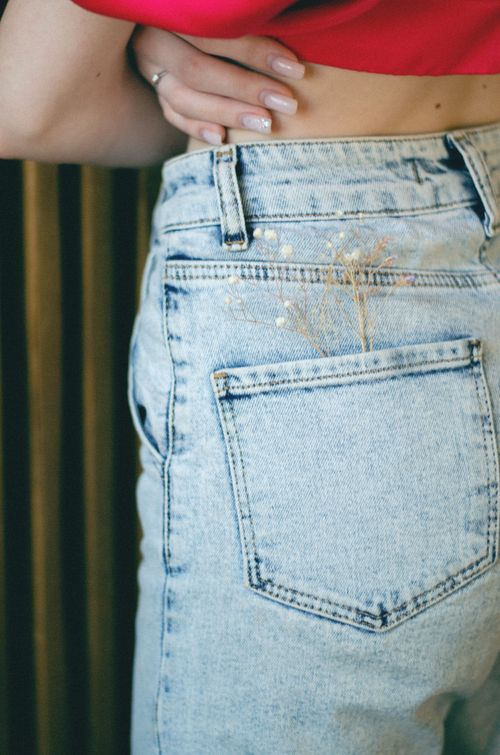 Free A close-up of denim jeans with decorative angel's breath flowers for a casual look. Stock Photo