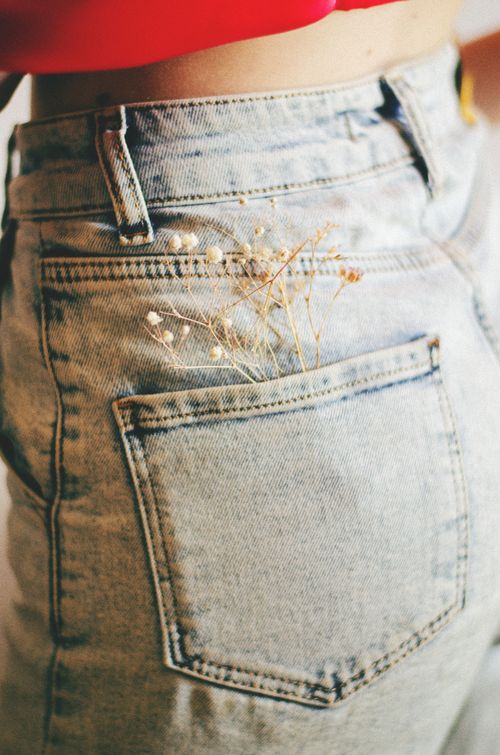 Free Close-up of denim jeans with delicate white flowers in back pocket, showcasing a stylish look. Stock Photo