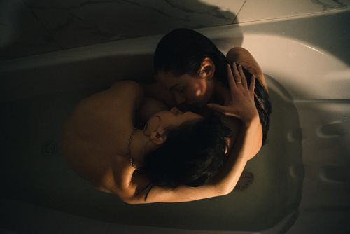 Free A tender and intimate moment of two women embracing in a bathtub, photographed from above. Stock Photo