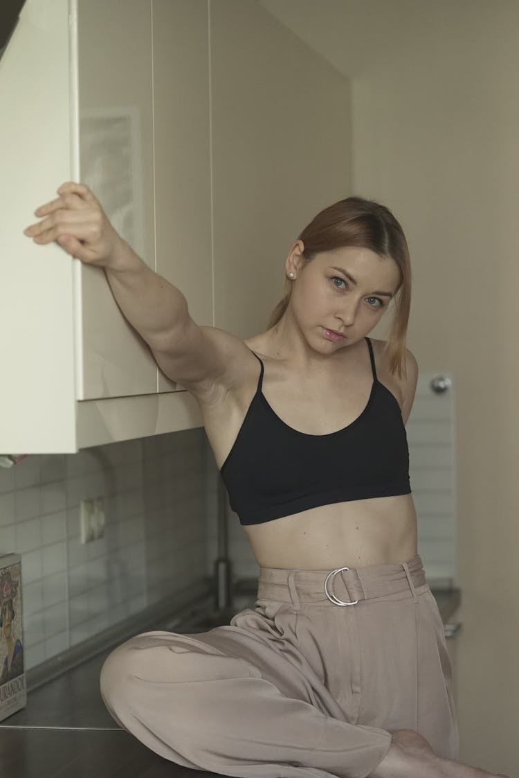 Girl Looking At Screen Sits In Home Kitchen 