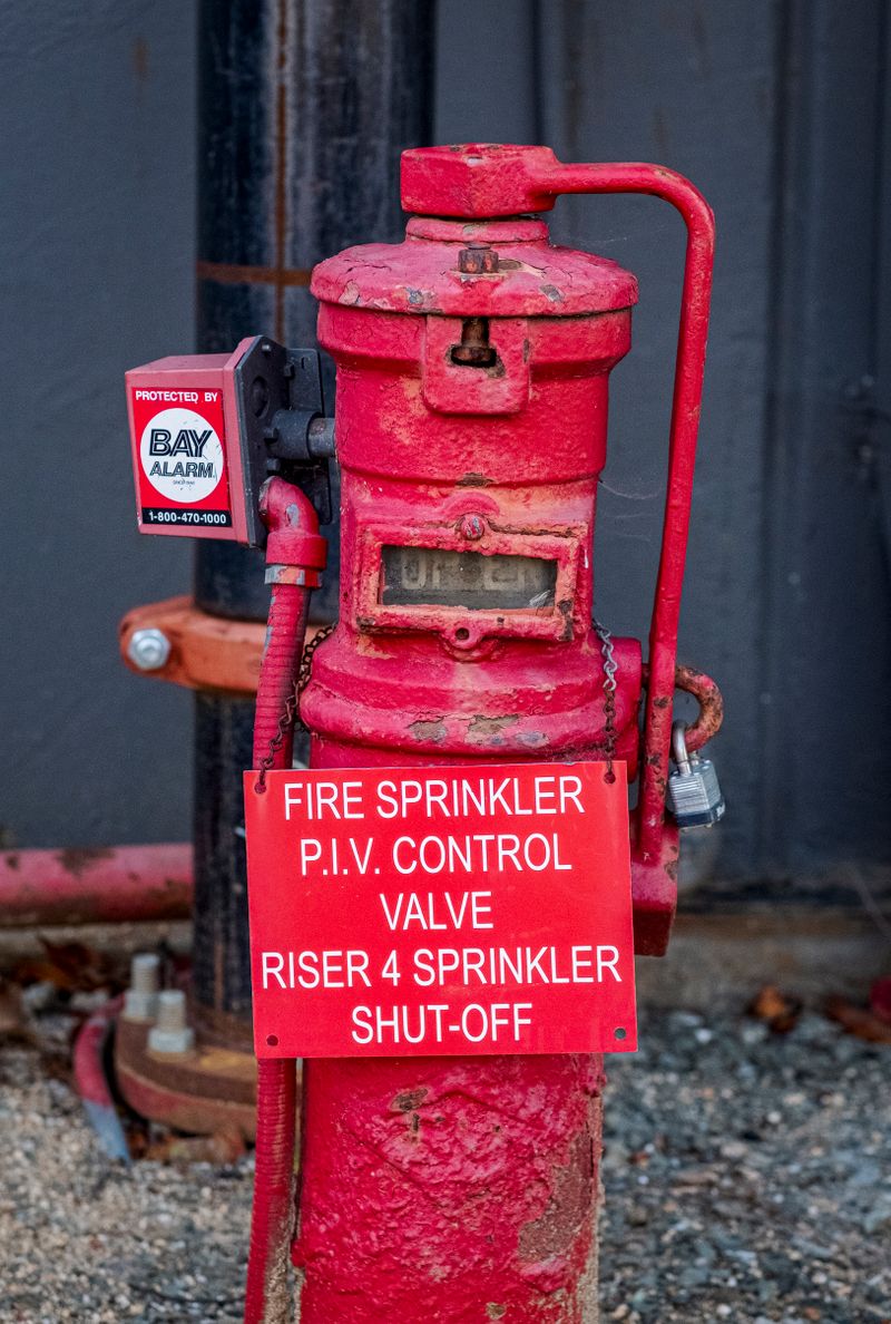 Red fire sprinkler control valve riser with a P.I.V. control valve sign