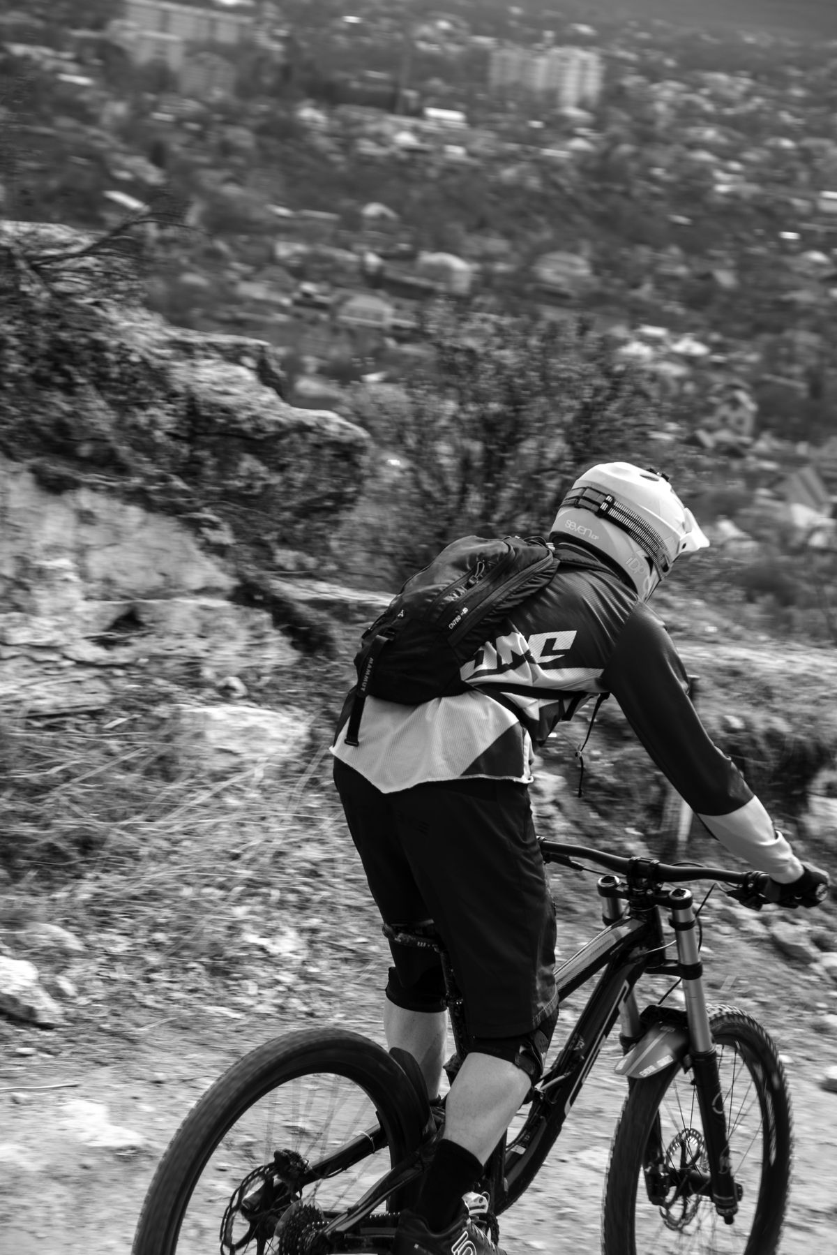 A rider descending a rugged downhill trail on a mountain bike.