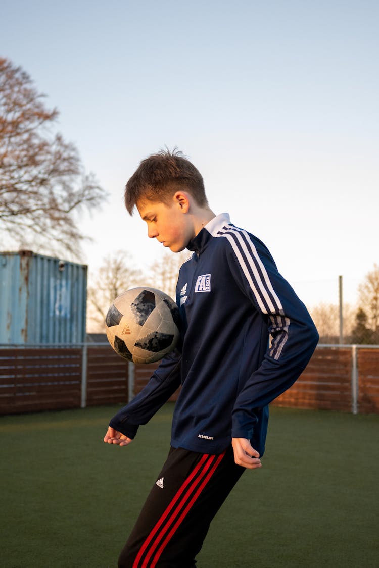 Side View Of A Boy Playing Football