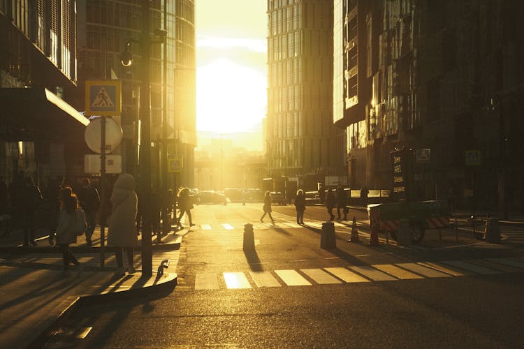 People Walking On City Street During Sunset