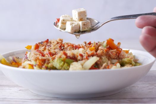 A delicious vegetarian salad with tofu, vegetables, and a savory dressing served in a bowl.