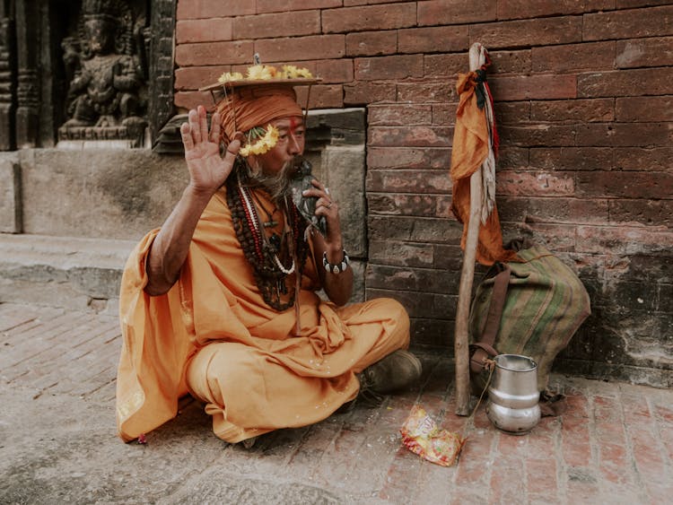 Elderly Man In Traditional Clothes Sitting On Ground