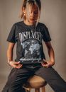 Woman in Black and White Crew Neck T-shirt and Black Denim Jeans Sitting on Chair