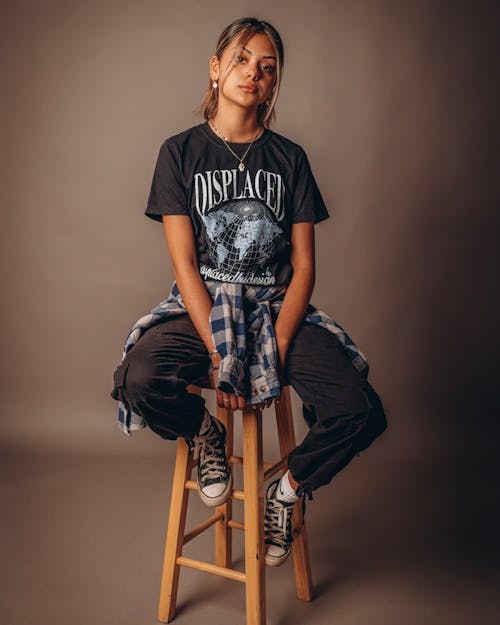 A Woman in Black T-shirt Sitting on a Stool