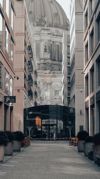 A narrow urban alleyway in Berlin with a view of the Berlin Cathedral dome.