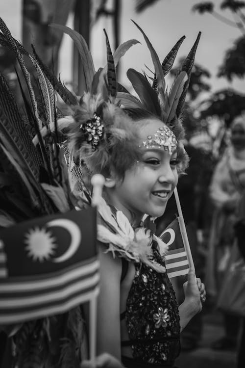 Grayscale Photo of a Girl in Traditional Clothing Holding a Flag