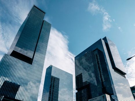Low-angle view of modern skyscrapers reaching into a clear blue sky, capturing urban architecture.