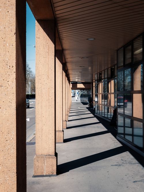 Free A city street view with modern architecture and columns, showcasing urban design in daylight. Stock Photo