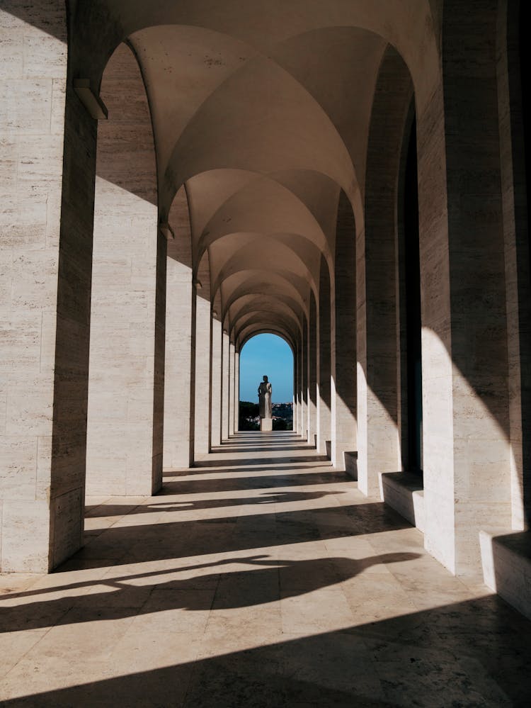 View Of Distant Statue Standing At End Of Colonnade