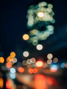 Blurred city lights create a vibrant bokeh effect against the night sky.