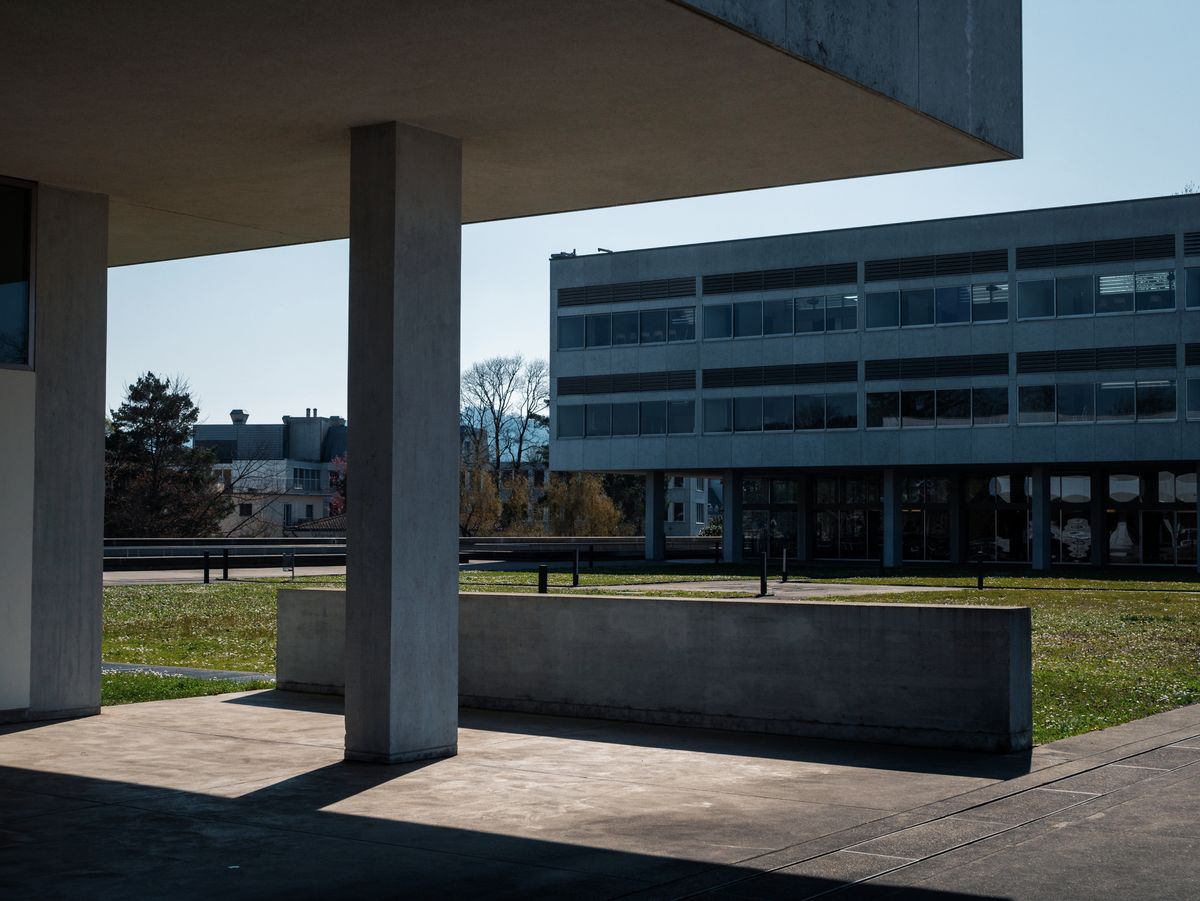 Modern concrete university building beside an open green space