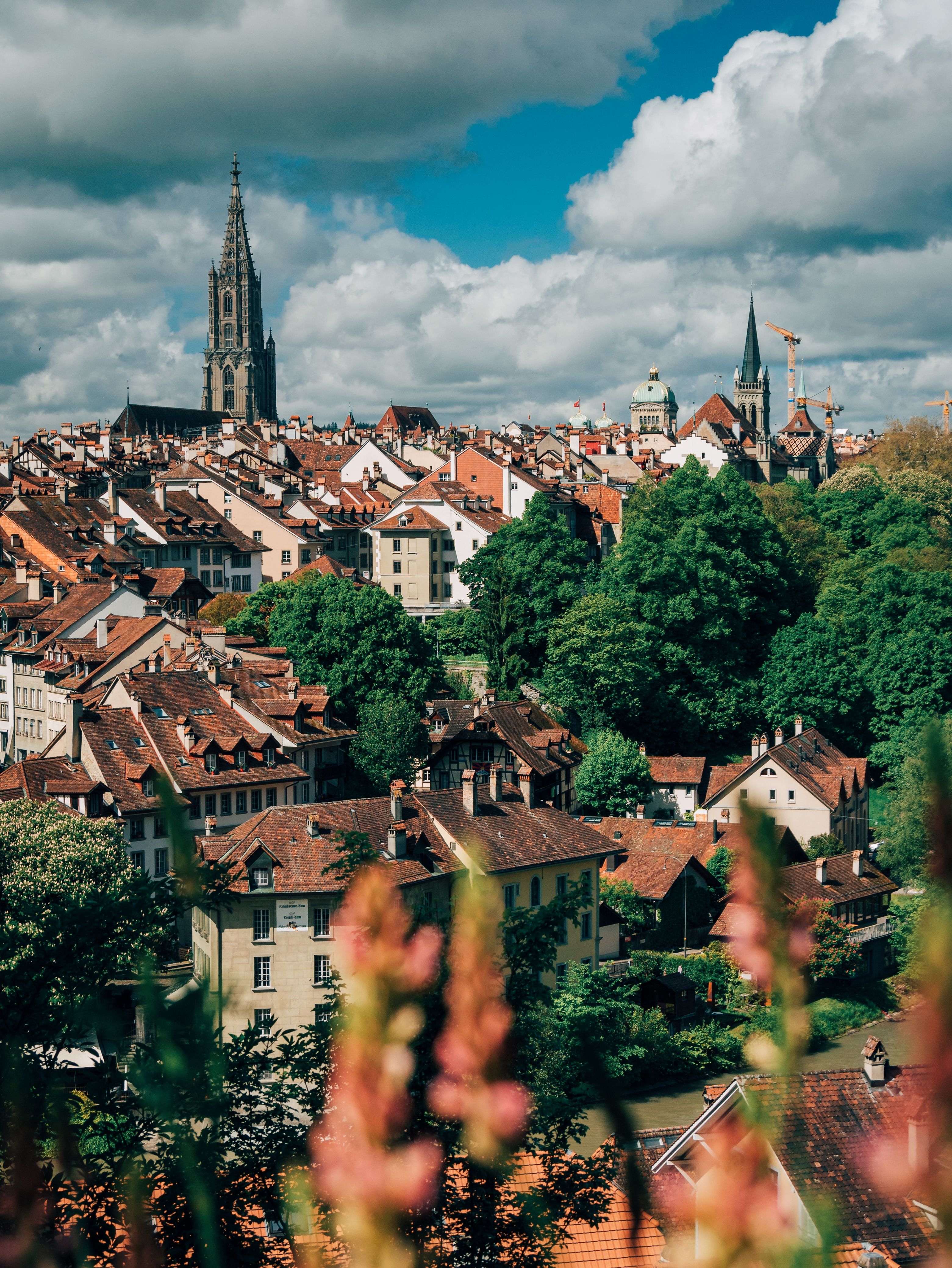 A scenic aerial view of Bern's old town showcasing historic architecture under a vibrant sky.