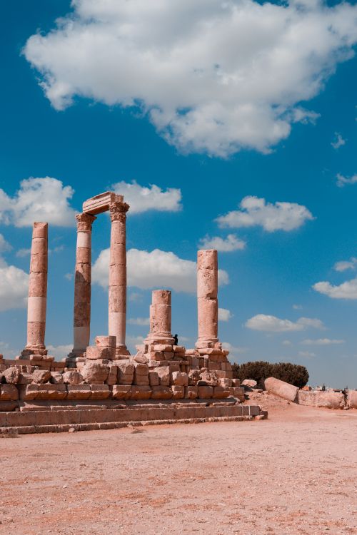 Free Explore ancient Roman ruins under a bright blue sky in Amman, showcasing rich history and stunning architecture. Stock Photo